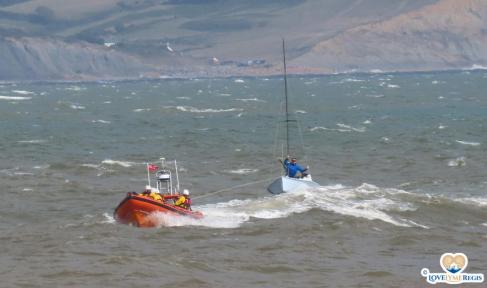 Lifeboat rescue towing a sailing boat in rough seas